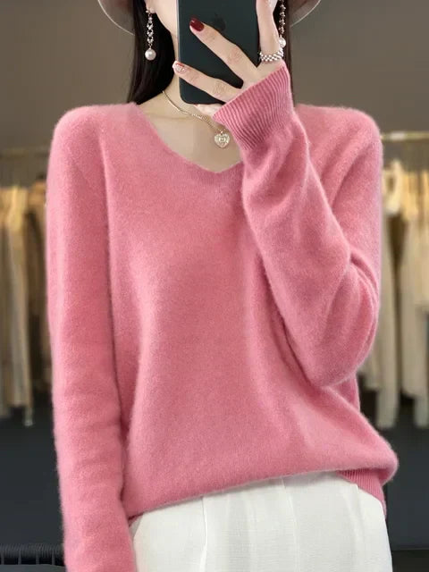 Person in a cozy pink loose knit sweater, standing in a fashion studio.
