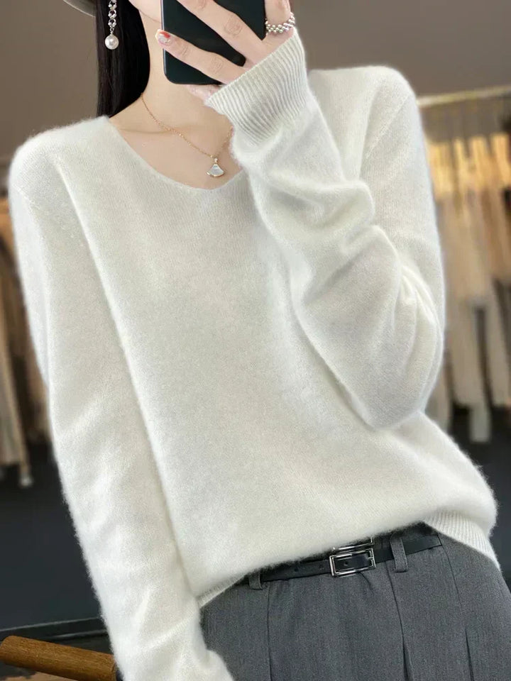 Person wearing an elegant white loose knit sweater in a bright fashion studio.