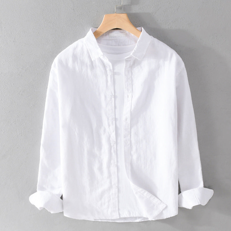 White shirt over white tee on hanger against gray wall.