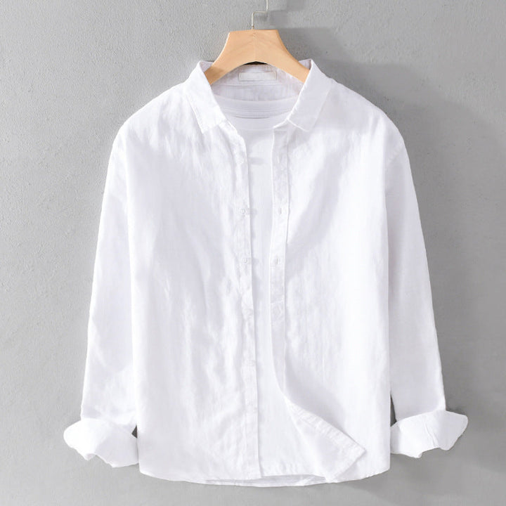 White shirt over white tee on hanger against gray wall.