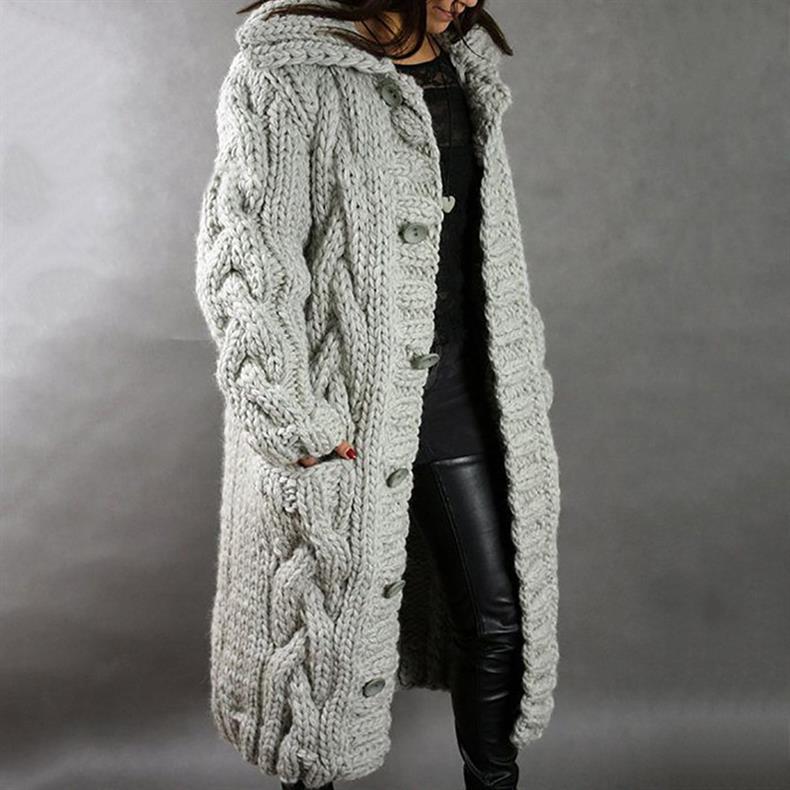 Light gray knitted coat with buttons, worn by a person in leather pants, studio setting.