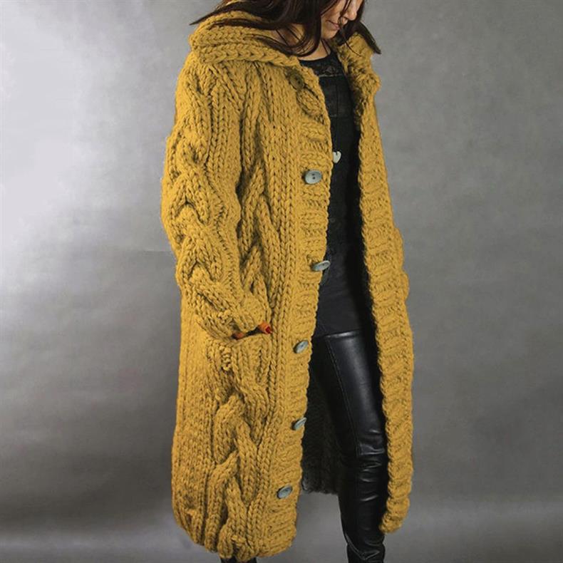 Mustard yellow knitted coat with buttons, worn by a person in leather pants, studio setting.