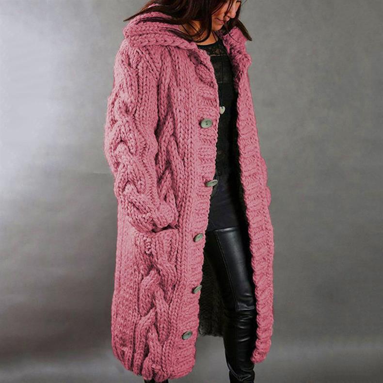 Pink knitted coat with buttons, worn by a person in leather pants, studio setting.
