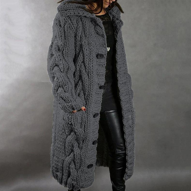 Dark gray knitted coat with buttons, worn by a person in leather pants, studio setting.