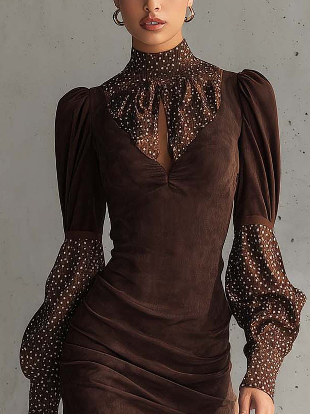 Close-up of brown bodycon dress featuring polka dot sleeves and high collar with ruching detail.