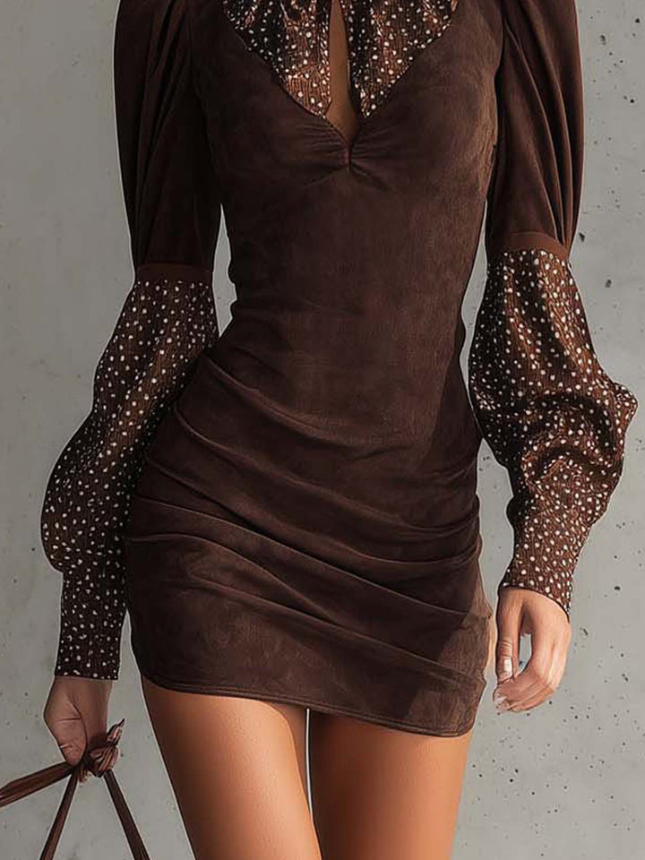 Detail of brown bodycon dress with fitted silhouette and polka dot-patterned sleeves.