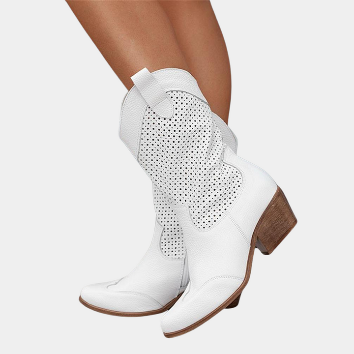 White perforated cowboy boots with wooden heels on white background.