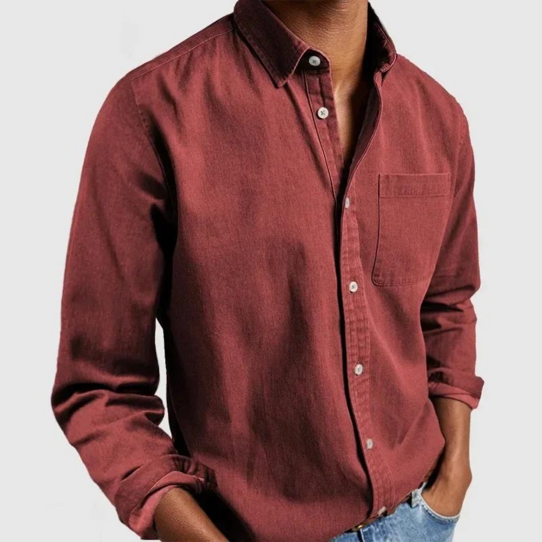 Dark red button-up shirt with front pocket and rolled sleeves, styled with hands in pockets; gray background.