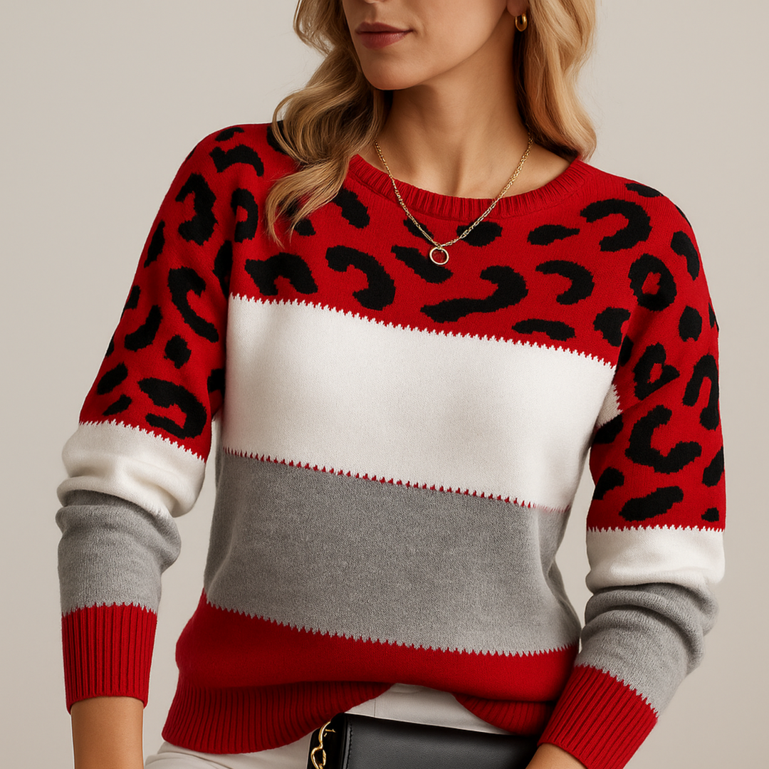 Vibrant red jumper with animal print pattern and gray, white stripes, worn by model in studio.
