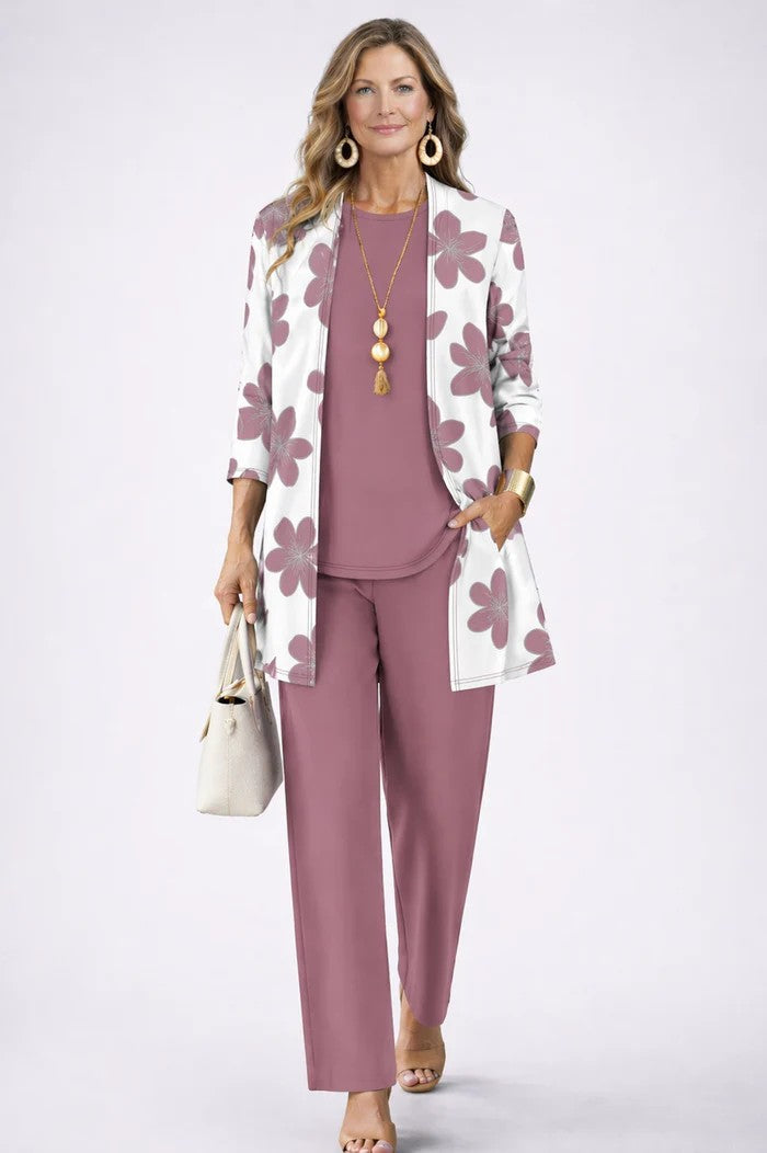 Woman wearing a mauve three-piece set with floral patterned cardigan. White studio backdrop.