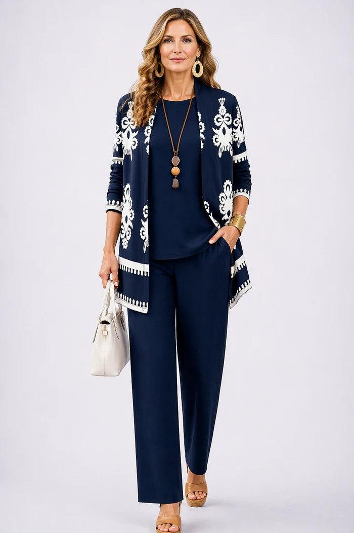 Woman in a navy blue three-piece set with a patterned cardigan. White studio background.