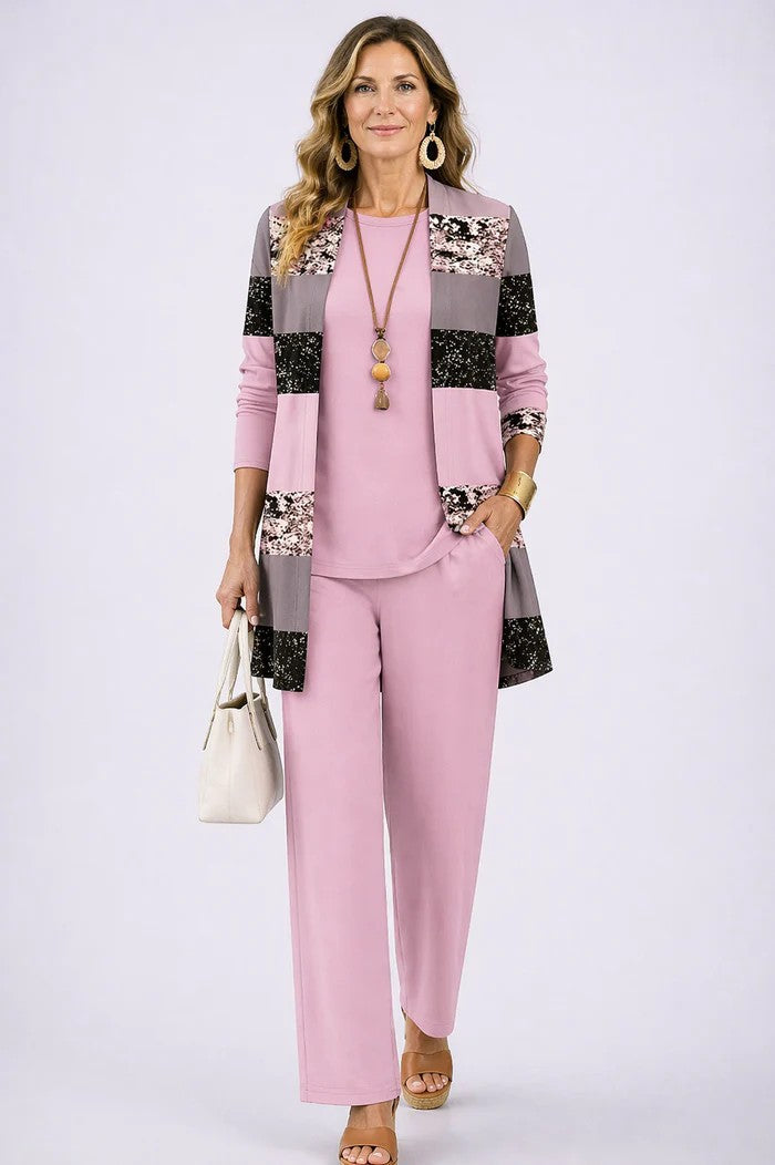 Woman in a soft pink three-piece set with a checkered cardigan. Studio background.