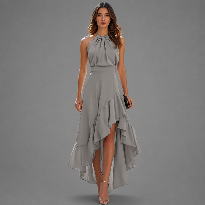 Stylish gray maxi dress with a halter neck and layered ruffled hem, set against a gray studio background.