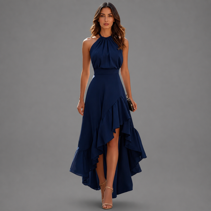 Chic navy blue maxi dress featuring a halter neck and flowing ruffled hem, displayed in a gray studio setting.