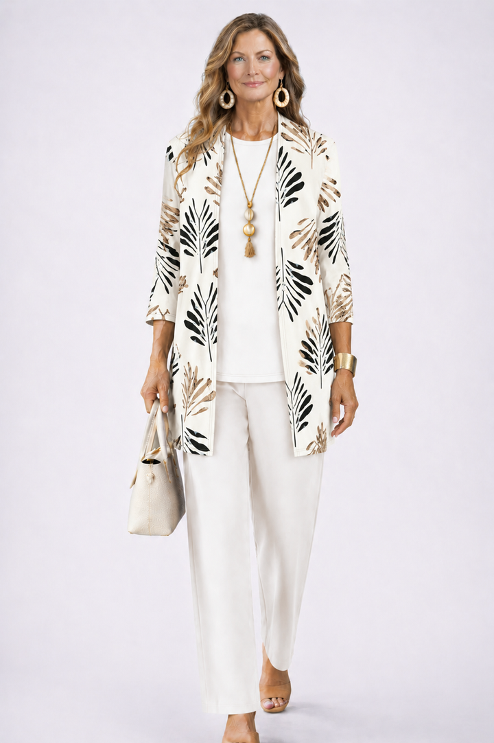 Woman wearing an ivory three-piece set with a leaf patterned cardigan. White studio setting.