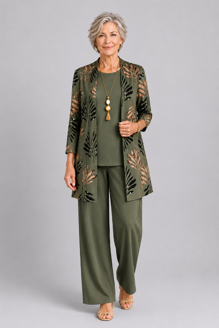Woman wearing an elegant olive green three-piece set with a patterned cardigan. Studio background.