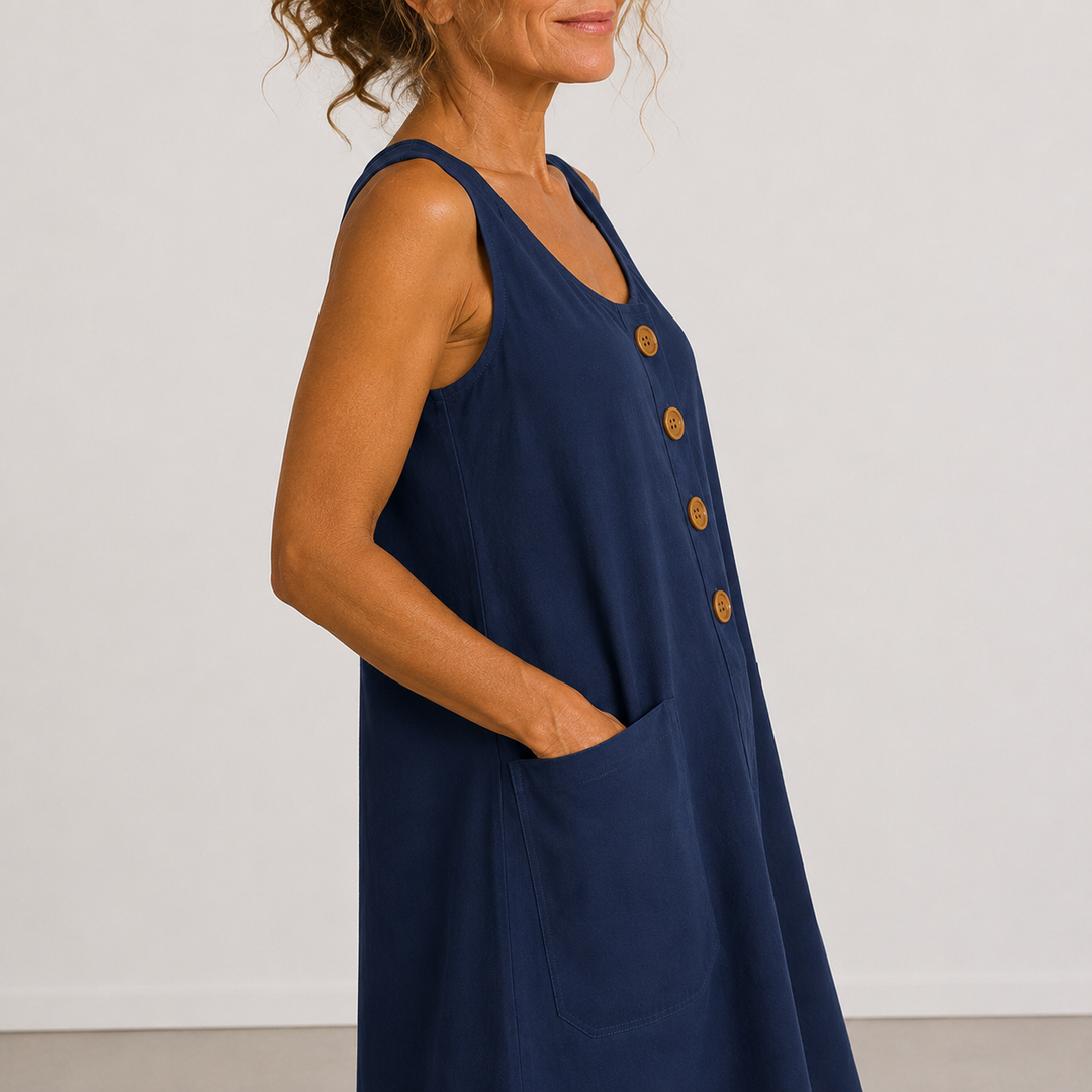 Close-up of a navy blue dress with buttons and pocket, worn in a studio setting.