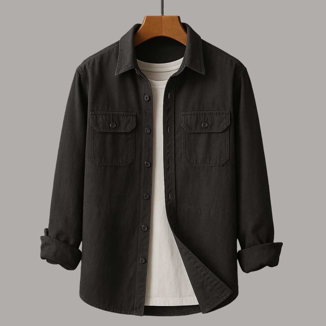 Dark charcoal shirt with chest pockets over a white tee on wooden hanger, gray studio background.