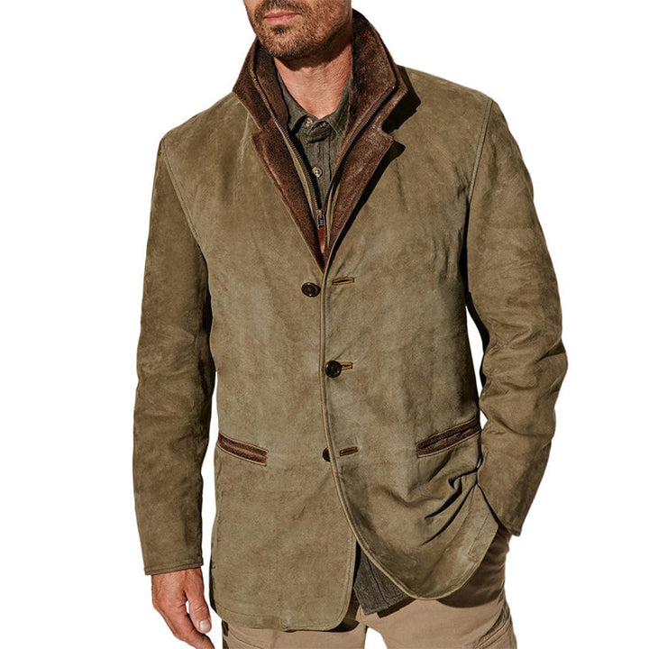 Man wearing a vintage buckskin jacket with button closure, brown collar, and front pockets in a studio setting.