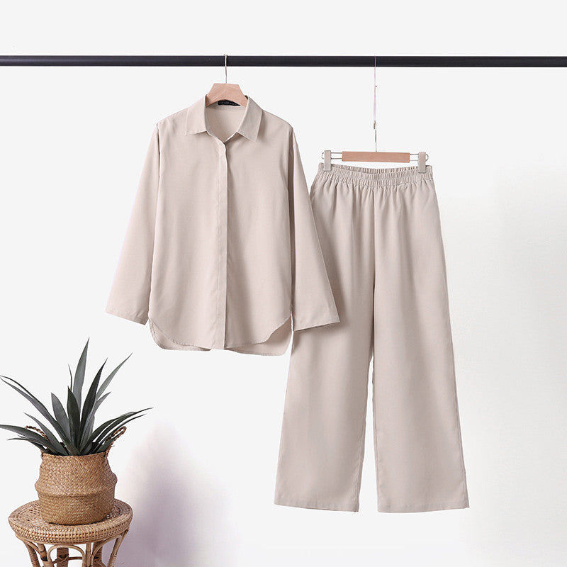 Light cream two-piece outfit displayed on a hanger indoors next to a wicker basket plant.
