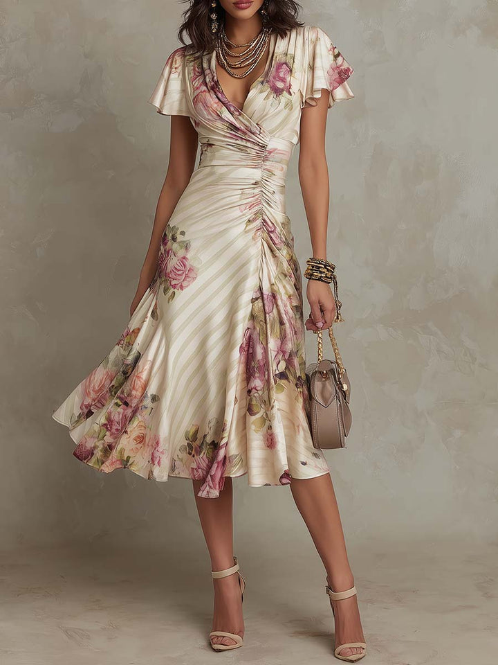 Elegant midi dress with floral design and ruched waistline, worn with accessories, in a studio setting.