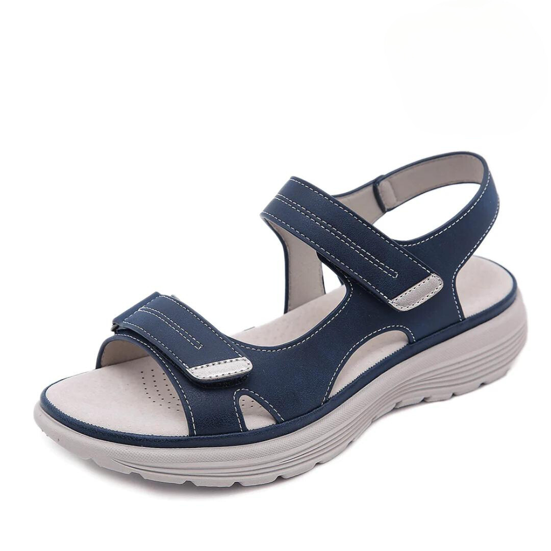 Blue orthopedic sandal with adjustable straps and cushioned sole, studio background.