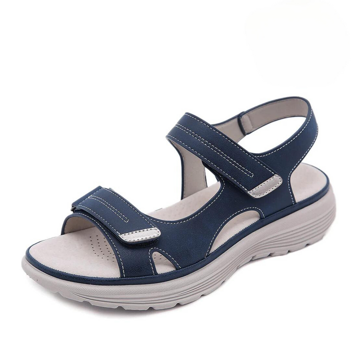 Blue orthopedic sandal with adjustable straps and cushioned sole, studio background.