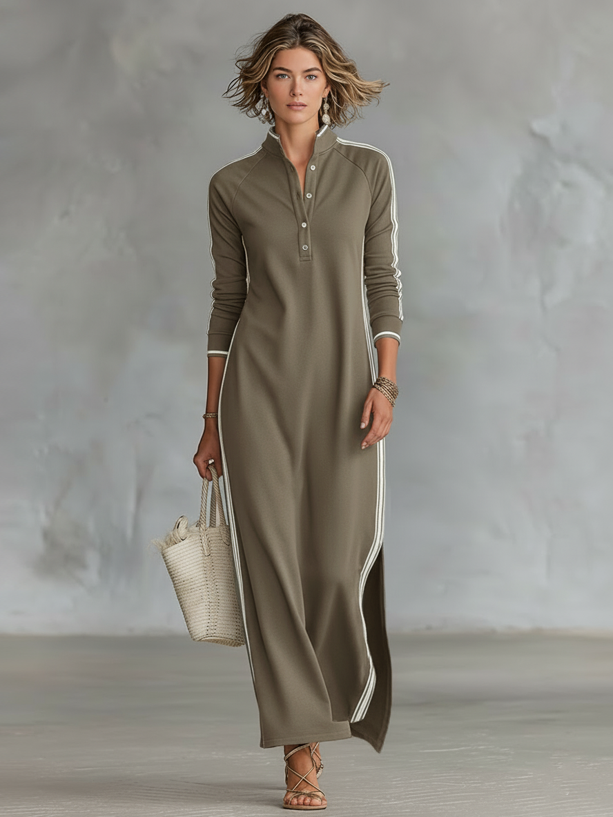 Olive maxi dress with vertical stripes, worn by a person holding a tote. Indoor neutral background.