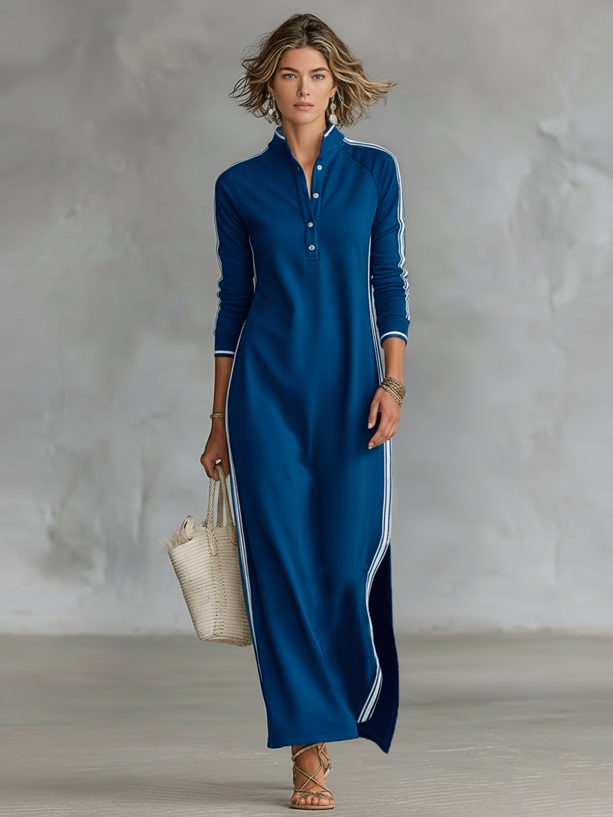 Blue maxi dress with white stripes, worn by a person holding a woven tote. Neutral indoor setting.