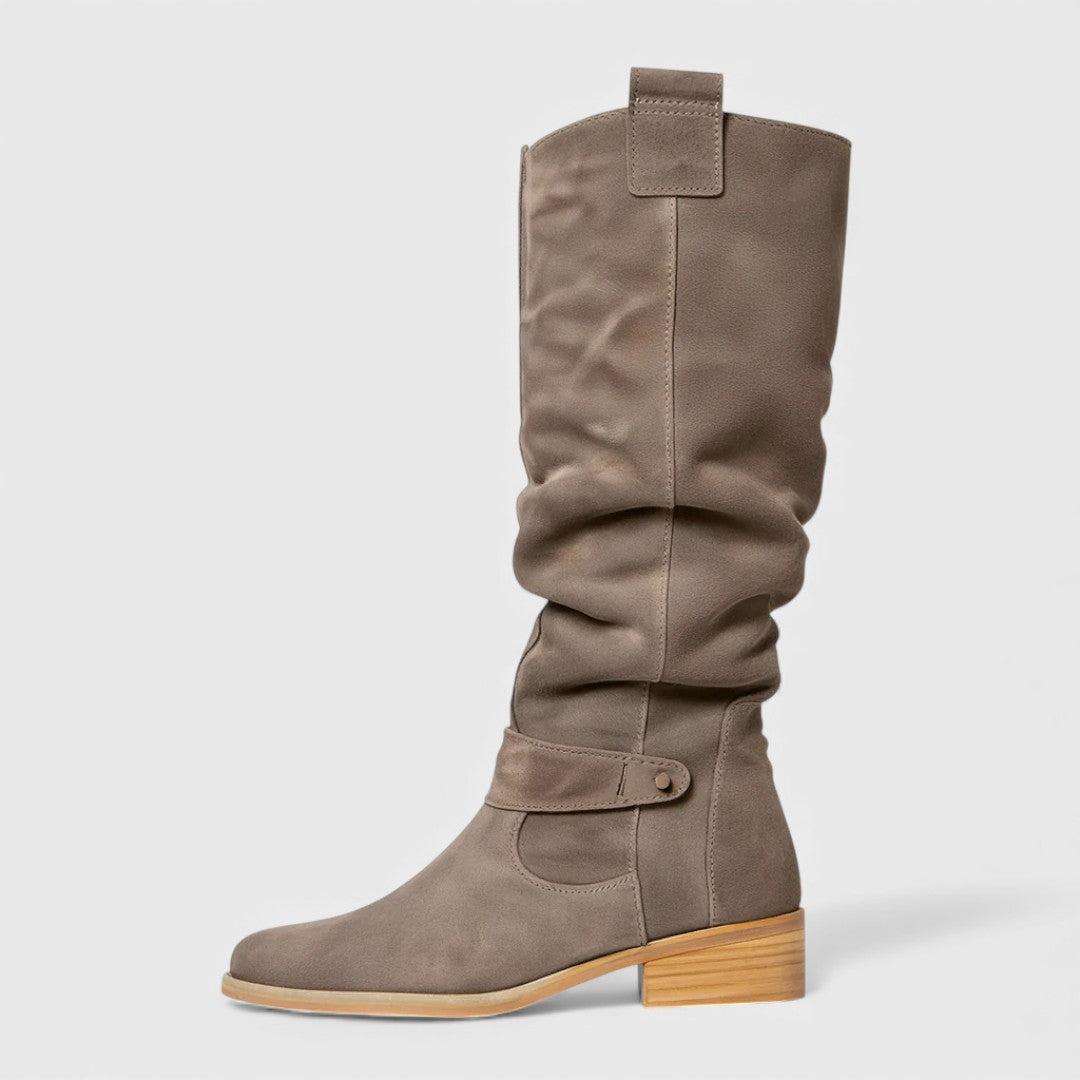 Single gray knee-high boot with buckle detail on a wooden heel, studio background.