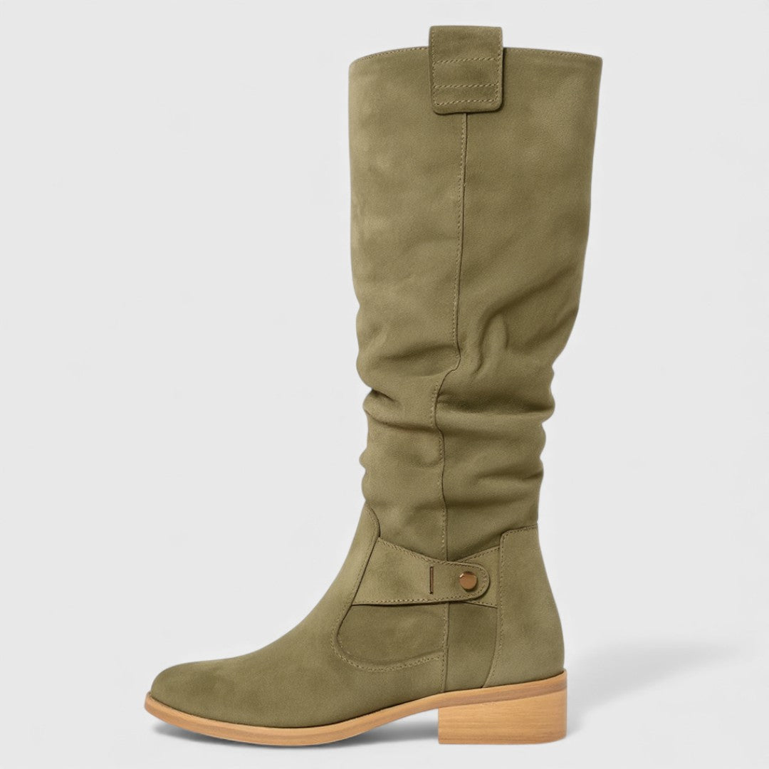 Single olive knee-high boot with buckle detail on a wooden heel, studio background.