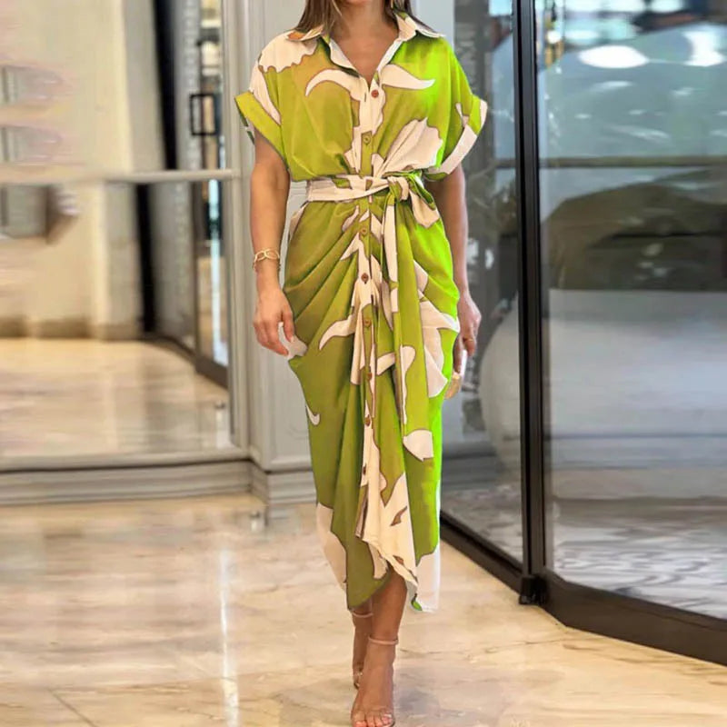 Lime green and beige wrap maxi dress with abstract design, displayed indoors on a glossy tiled floor.