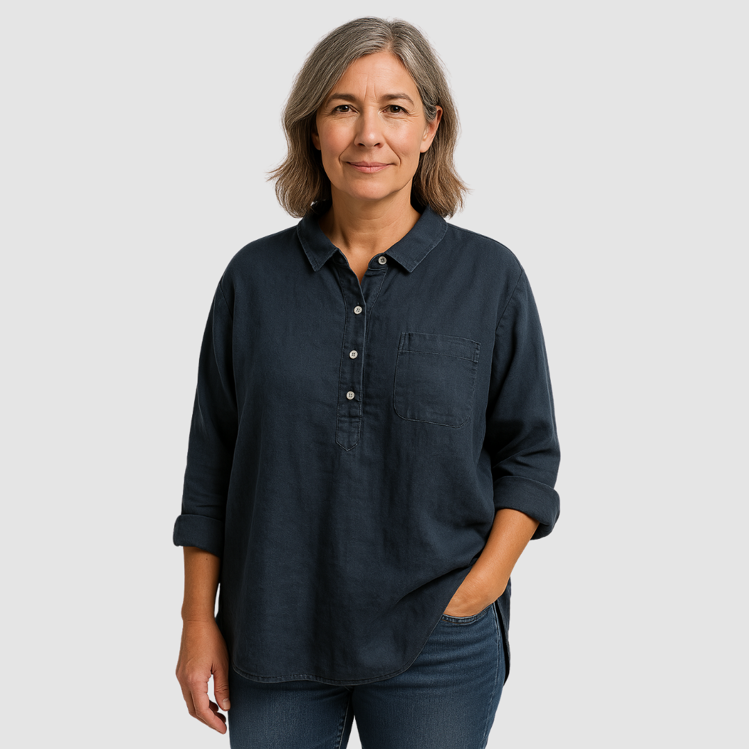 Model wearing dark, long-sleeve blouse with button-down front and chest pocket, standing against a light gray background.