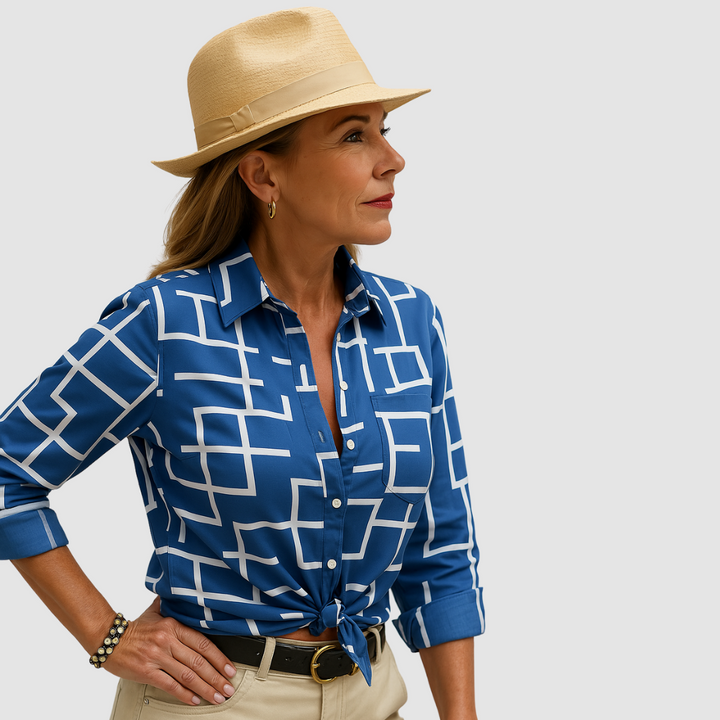 Blue blouse with geometric white pattern, worn by person with tan hat; neutral studio background.