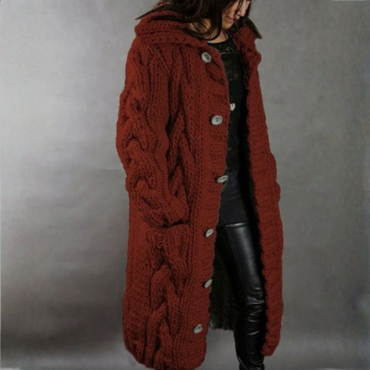 Rust red knitted coat with buttons, worn by a person in leather pants, studio setting.