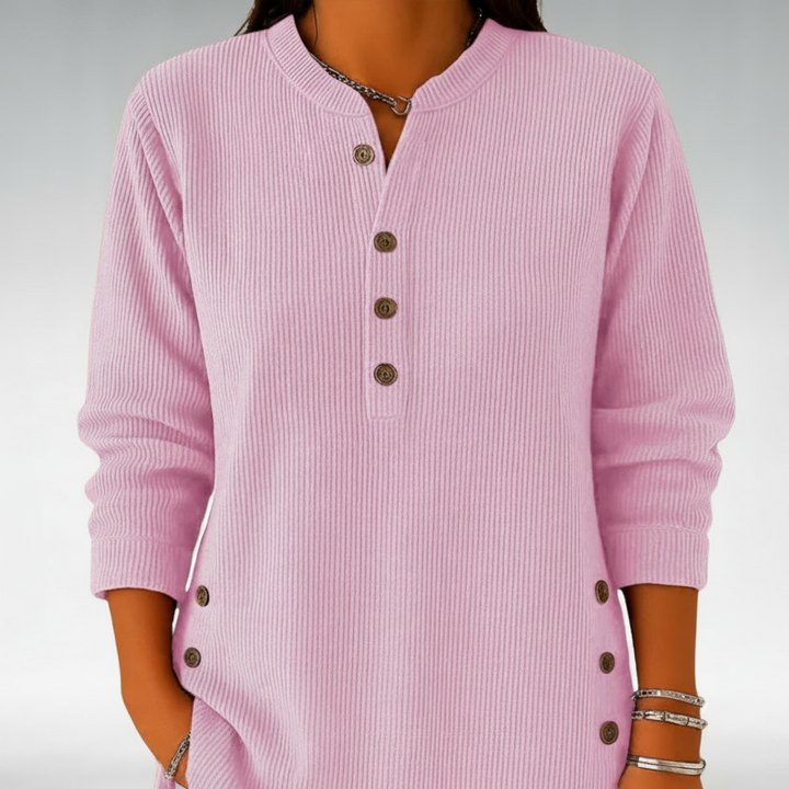 Light pink jumper with buttons shown in a clean studio background.