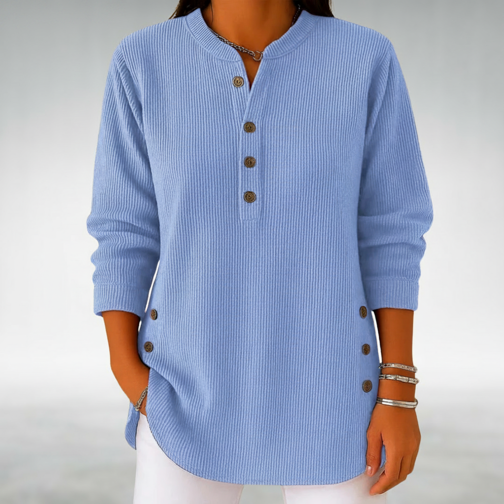 Light blue jumper with buttons displayed in a minimalistic studio setting.