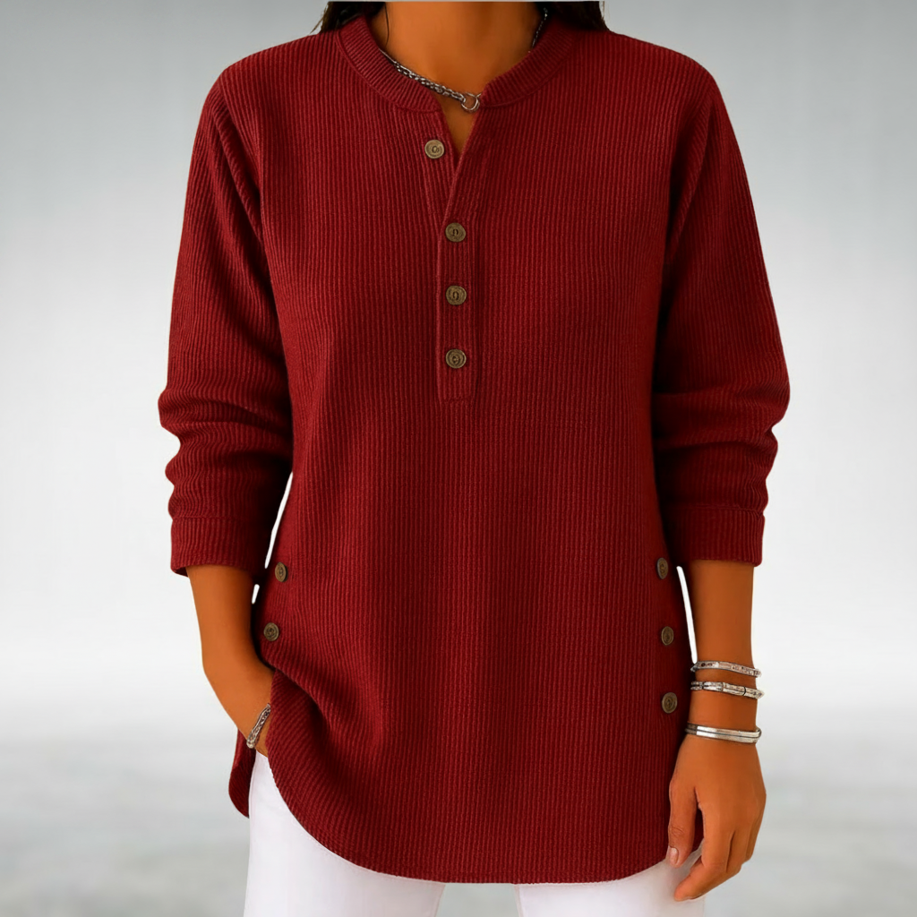 Rich red jumper with buttons against a neutral studio background.