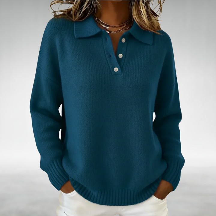 Teal cozy jumper with a buttoned collar, worn with white pants in a studio setting.