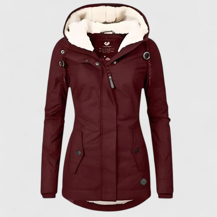 Burgundy winter coat with hood, soft interior lining, and button details in a studio setting.
