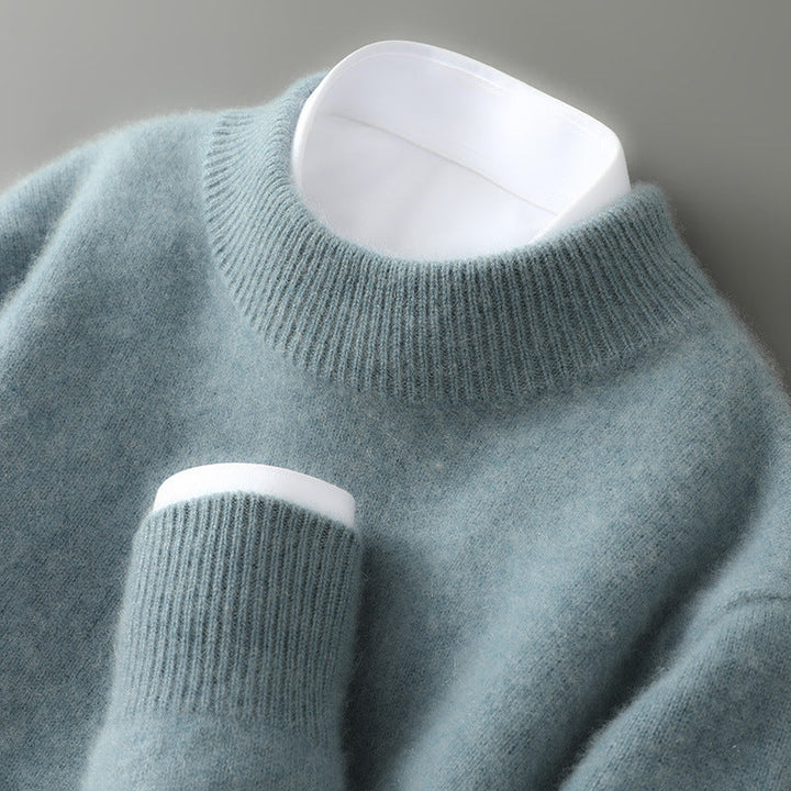 Close-up of a soft, light blue sweater with a ribbed turtleneck and cuff on a neutral background.
