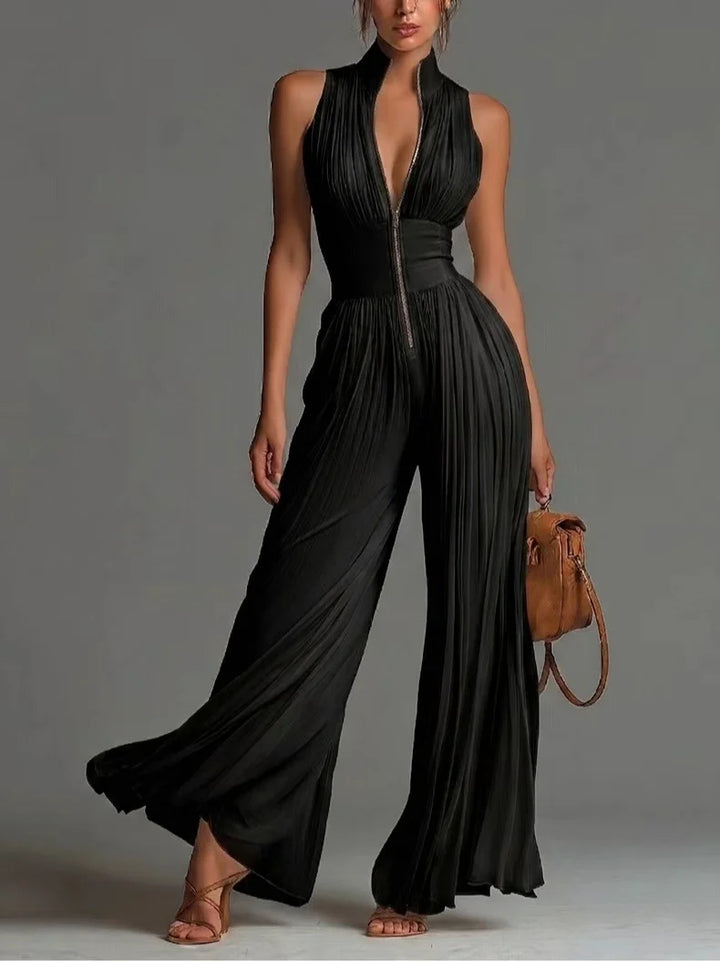 Elegant black jumpsuit with pleated design and zip detail in studio setting.