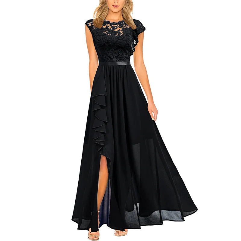 Elegant black dress with lace bodice and flowing skirt, featuring a ruffled slit, displayed on a model in studio setting.