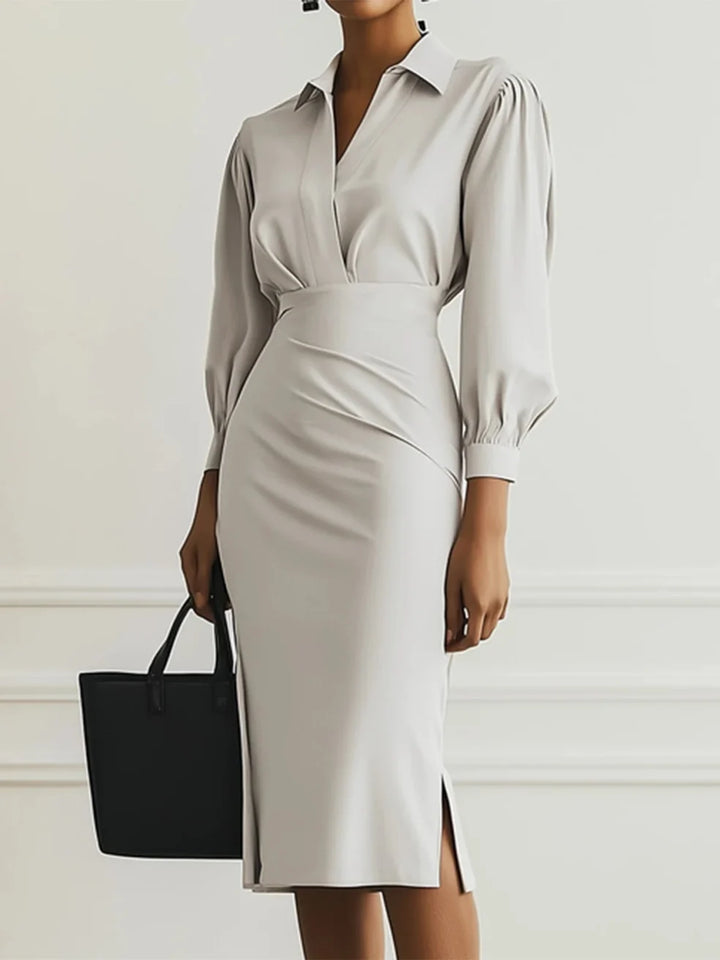 Light gray elegant maxi dress featuring puff sleeves and sleek fit, accessorized with a black tote bag in a studio setting.