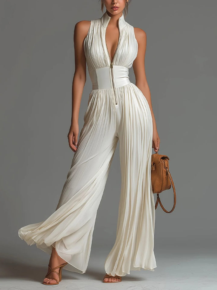 White pleated jumpsuit with zip detail in studio setting.