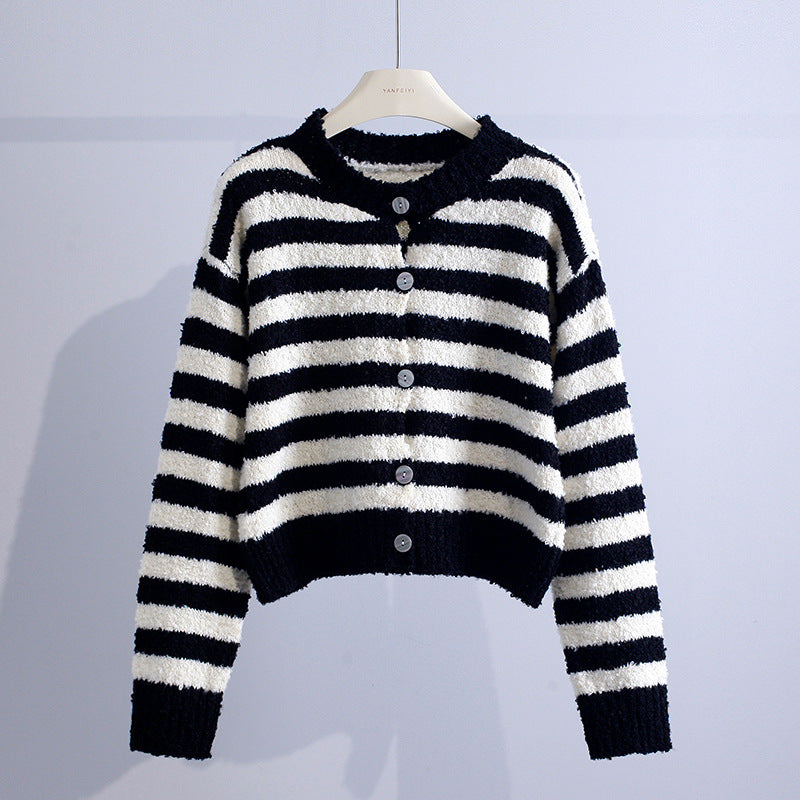Black and white striped cardigan with buttons, set against a light gray studio backdrop.