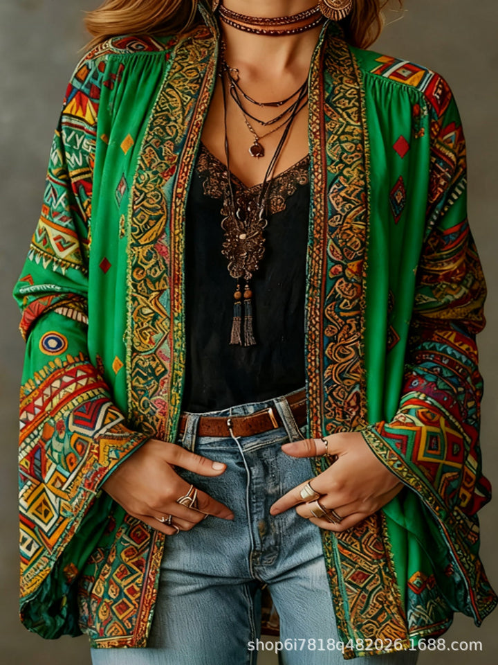 Woman modeling a vibrant green and red boho kimono cardigan, layered jewelry, and denim jeans, studio setting.
