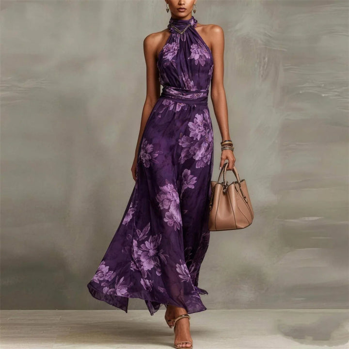 Purple floral halter-neck maxi dress in studio setting with beige handbag.