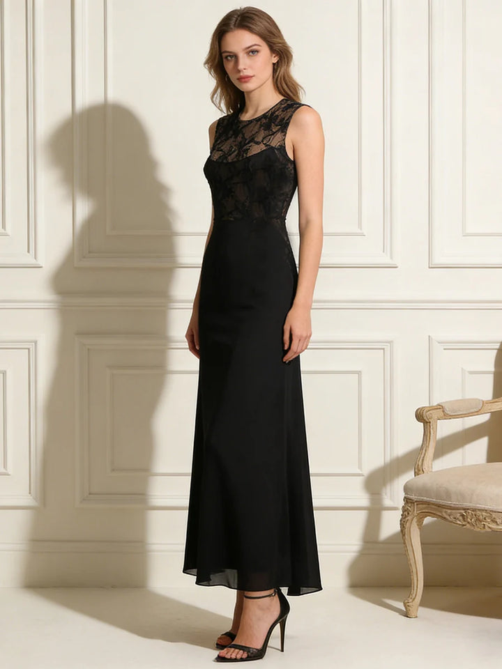 Elegant black dress with lace bodice and sleeveless design, worn by model in an ornate studio setting with classic furniture.