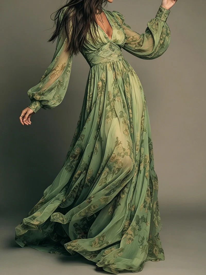 Flowing green maxi dress with floral patterns, featuring long sheer sleeves, modeled in a studio setting.
